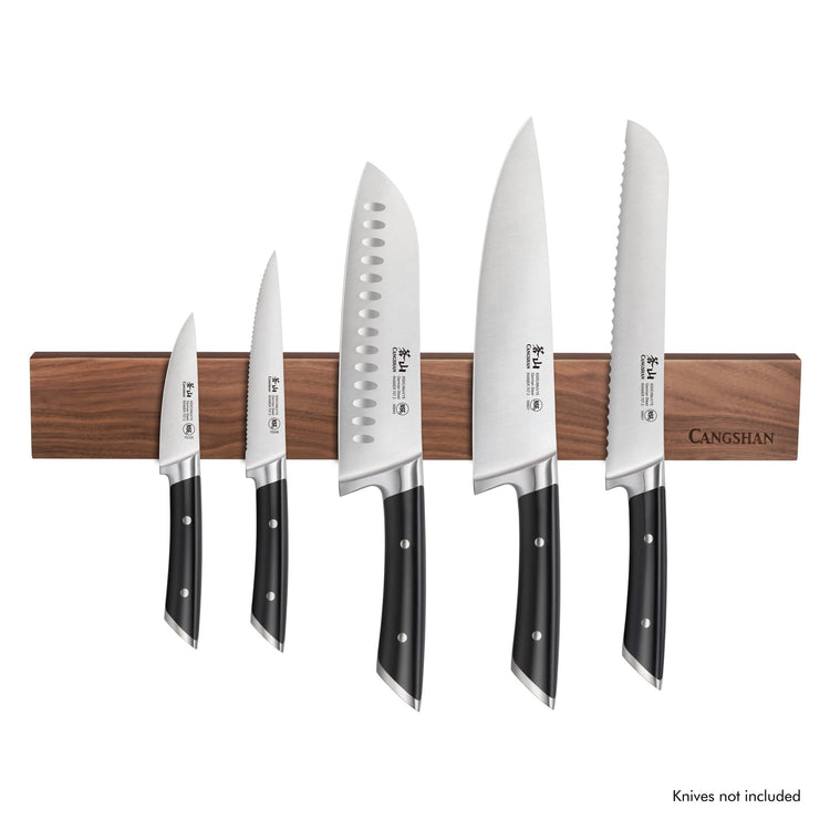 Walnut magnetic knife bar mounted with five kitchen knives of varying sizes and blade shapes.