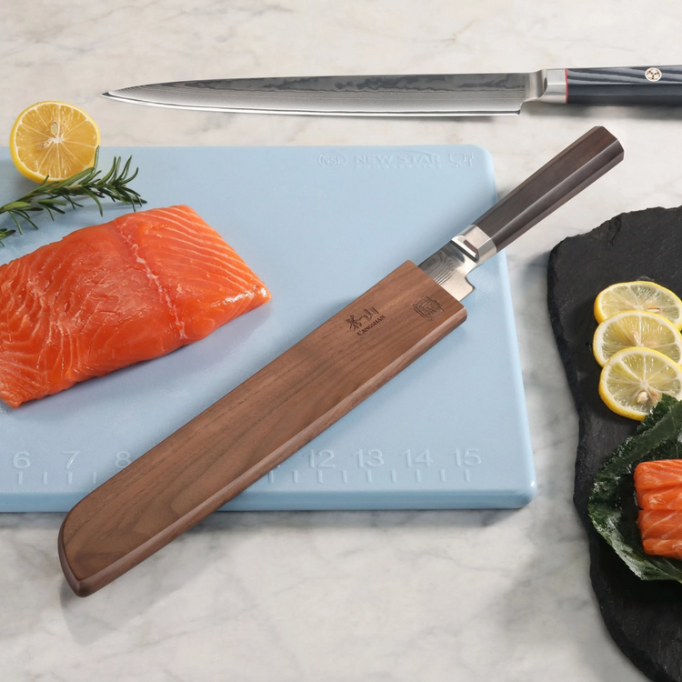 Walnut magnetic knife sheath covering a knife blade on a cutting board next to salmon, lemon, and herbs.
