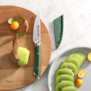 
                    
                      Paring knife with green handle and sheath next to peeled kiwi and sliced kiwi on a wooden board and plate.
                    
                  