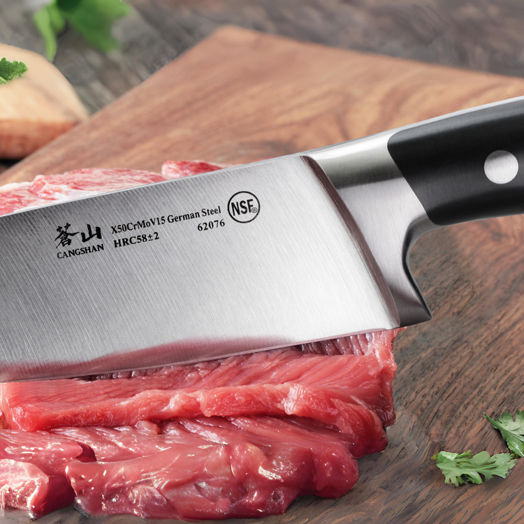 Close-up of a German steel chef's knife cutting raw red meat on a wooden board.