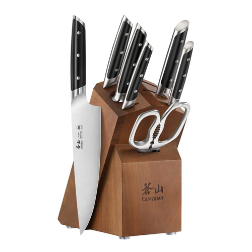 Wooden knife block holding six knives with black handles and a pair of kitchen scissors.