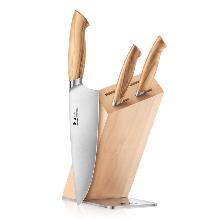 Four-piece knife block set with three knives in a light wood block and one large chef's knife resting against it.