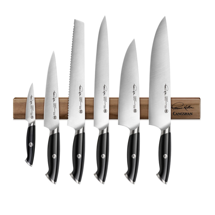 Seven black-handled knives of varying sizes attached to a wooden magnetic knife block.