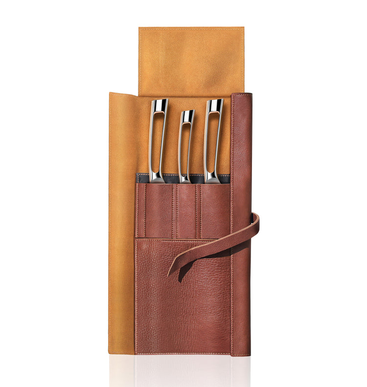 Four silver knives with hollow handles in a brown leather roll-up case with a tie strap.