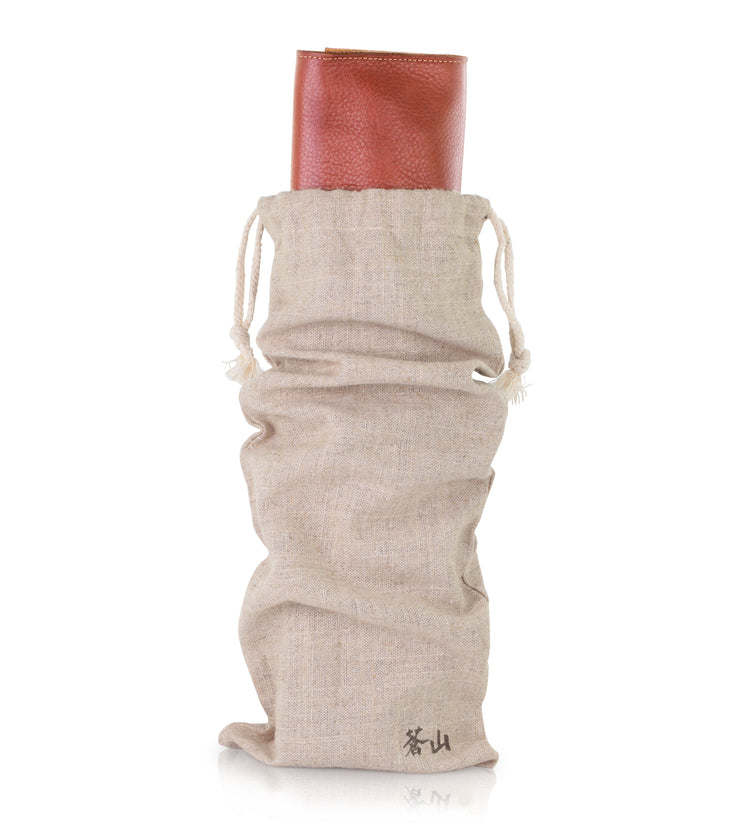 Beige drawstring fabric pouch holding a rolled-up brown leather knife case.