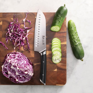 
                    
                      Santoku knife on wooden cutting board with sliced cucumber and shredded purple cabbage.
                    
                  