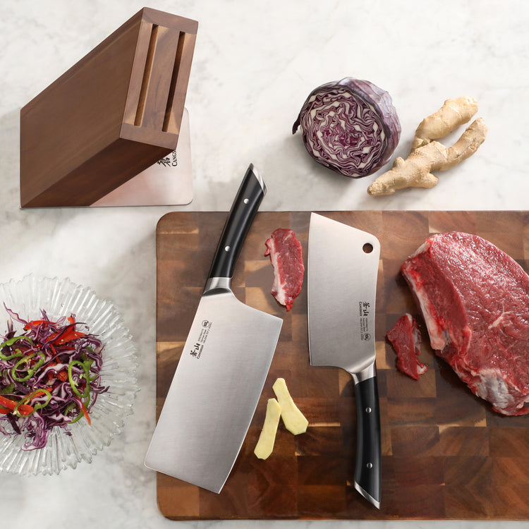 Two cleaver knives with black handles on a wooden cutting board with raw beef, ginger, and red cabbage, next to an empty acac