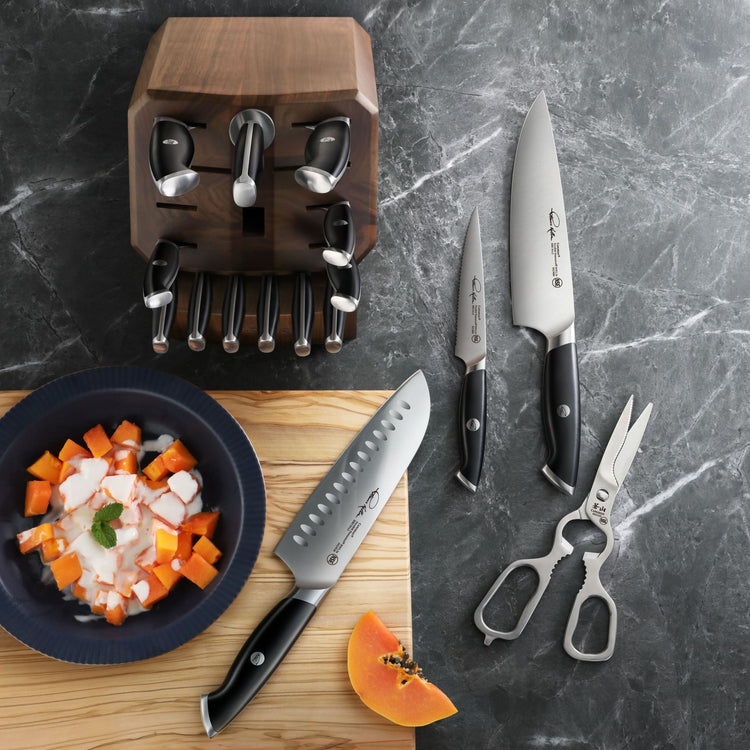 TKSC 17-piece knife block set featuring a wooden knife block, steel kitchen knives, and shears on a marble counter.
